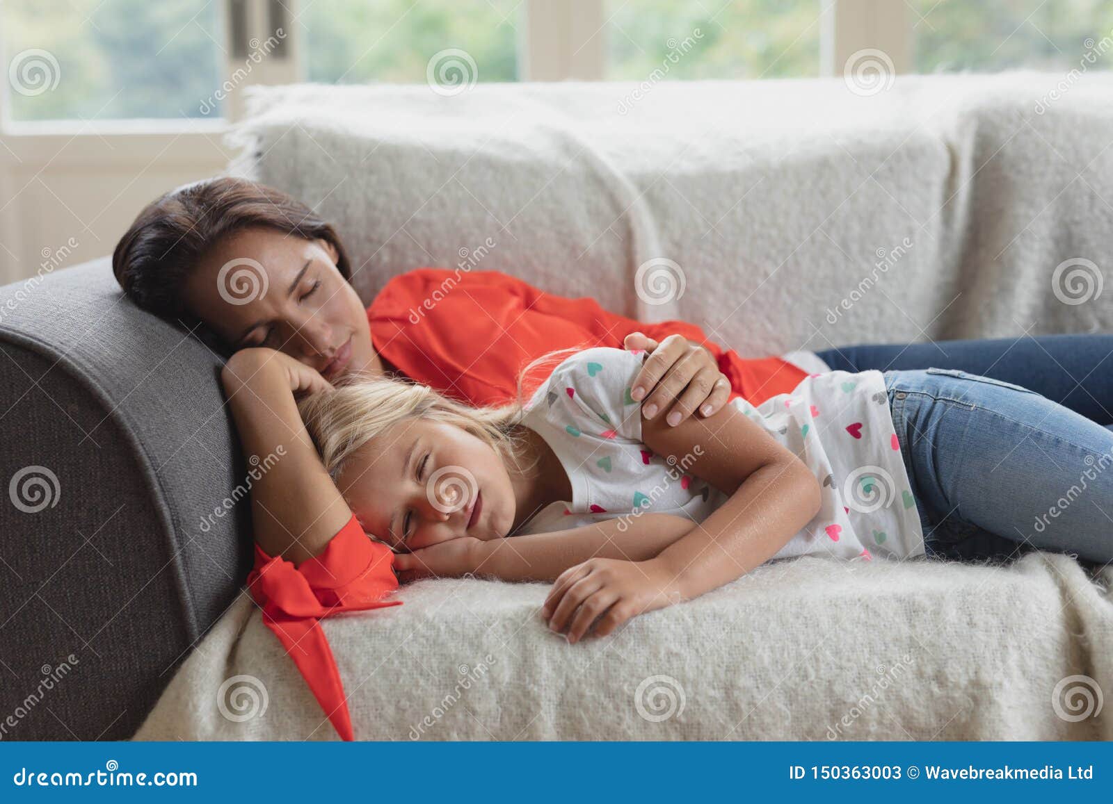 Mother And Daughter Sleeping Together On A Sofa In Living Room Stock 