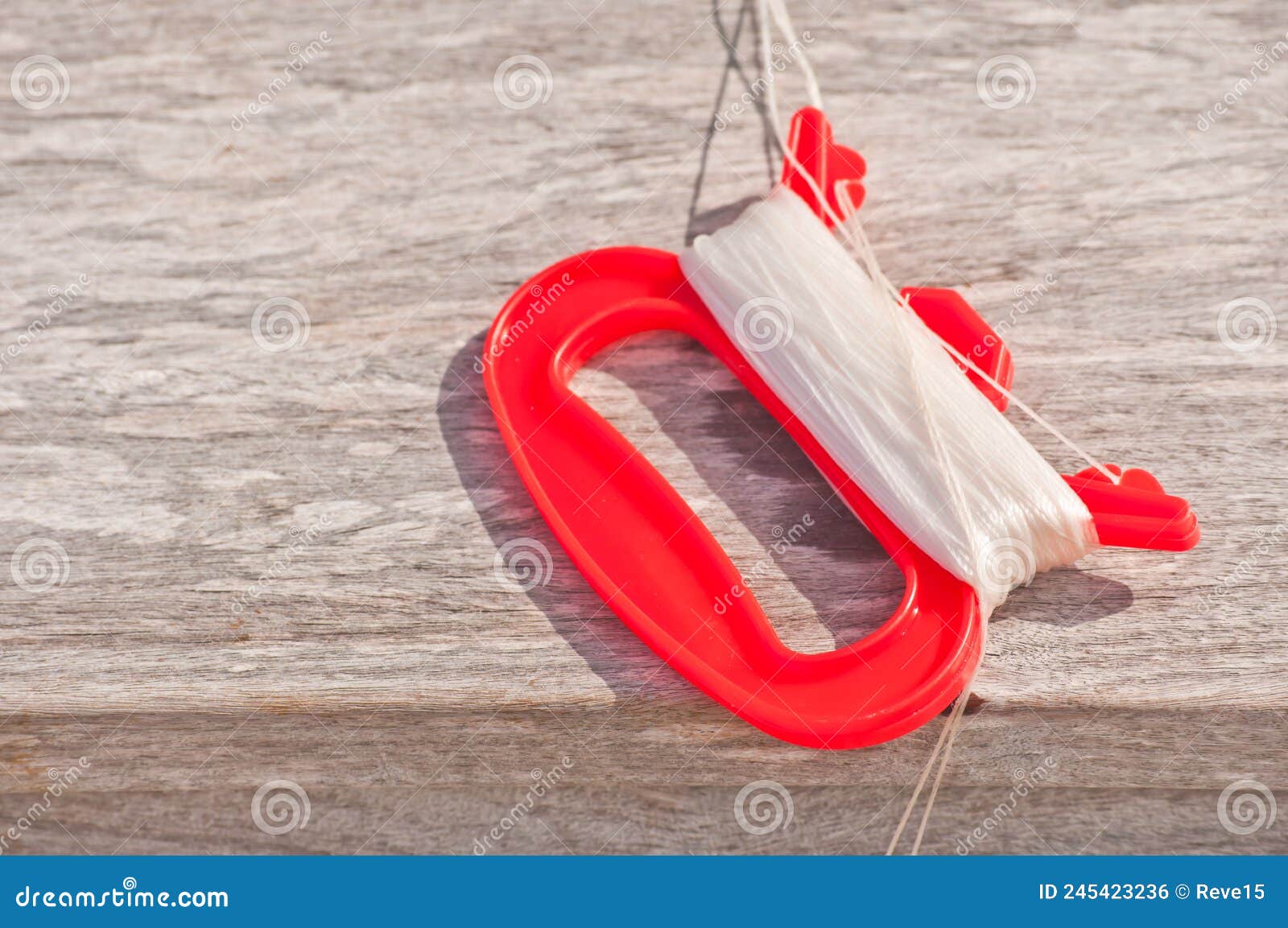 Orange, Plastic Fishing Line Holder with White Fishing Line Wrapped Around  Handle Stock Photo - Image of plastic, line: 245423236