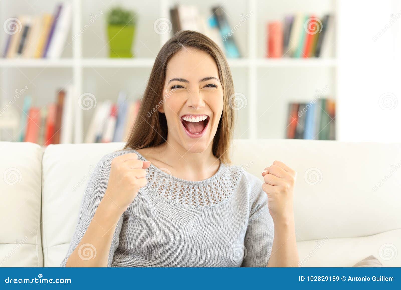 front view of an excited woman looking at camera at home