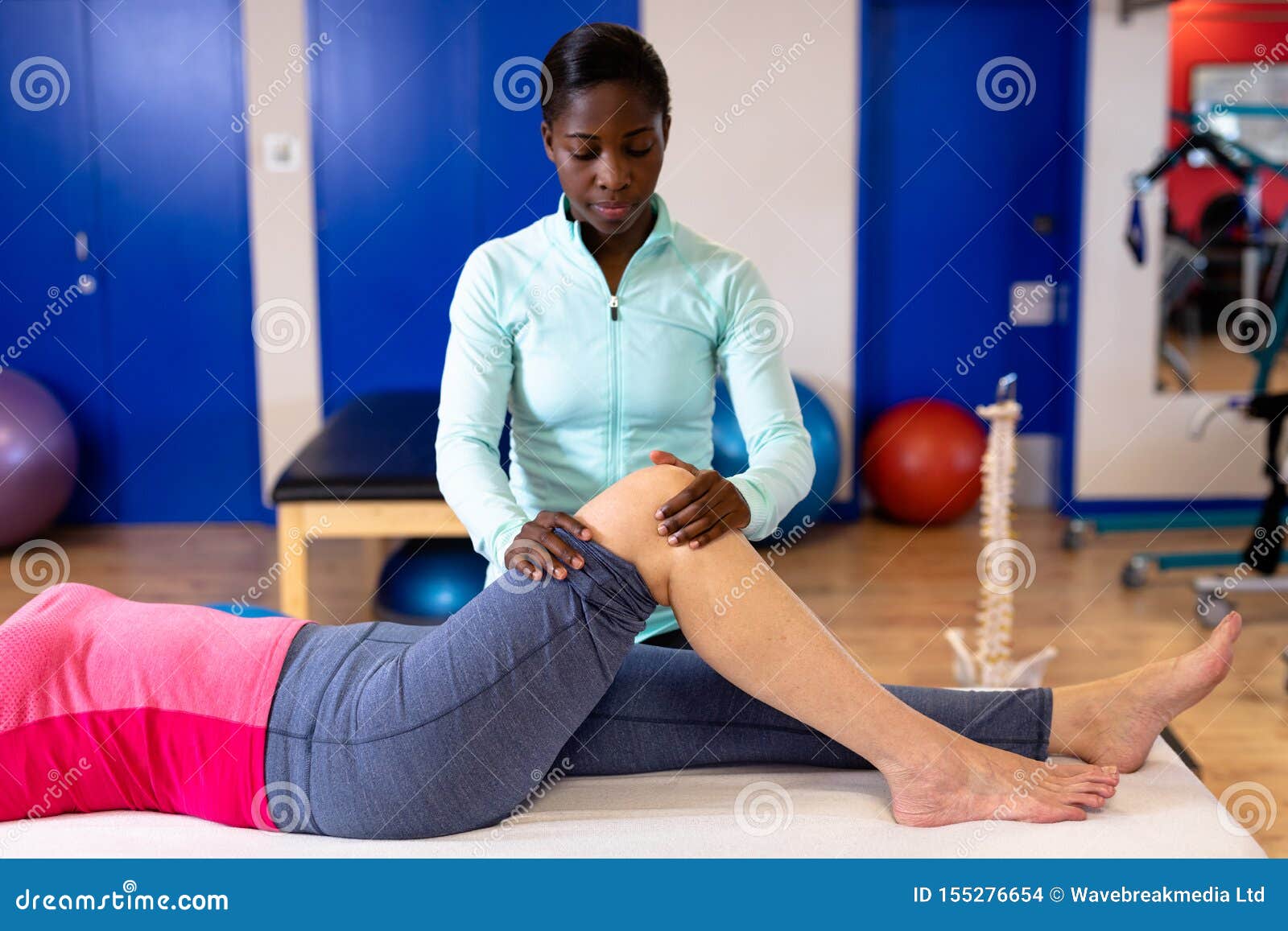 Female Physiotherapist Giving Leg Massage To Active Senior Woman In