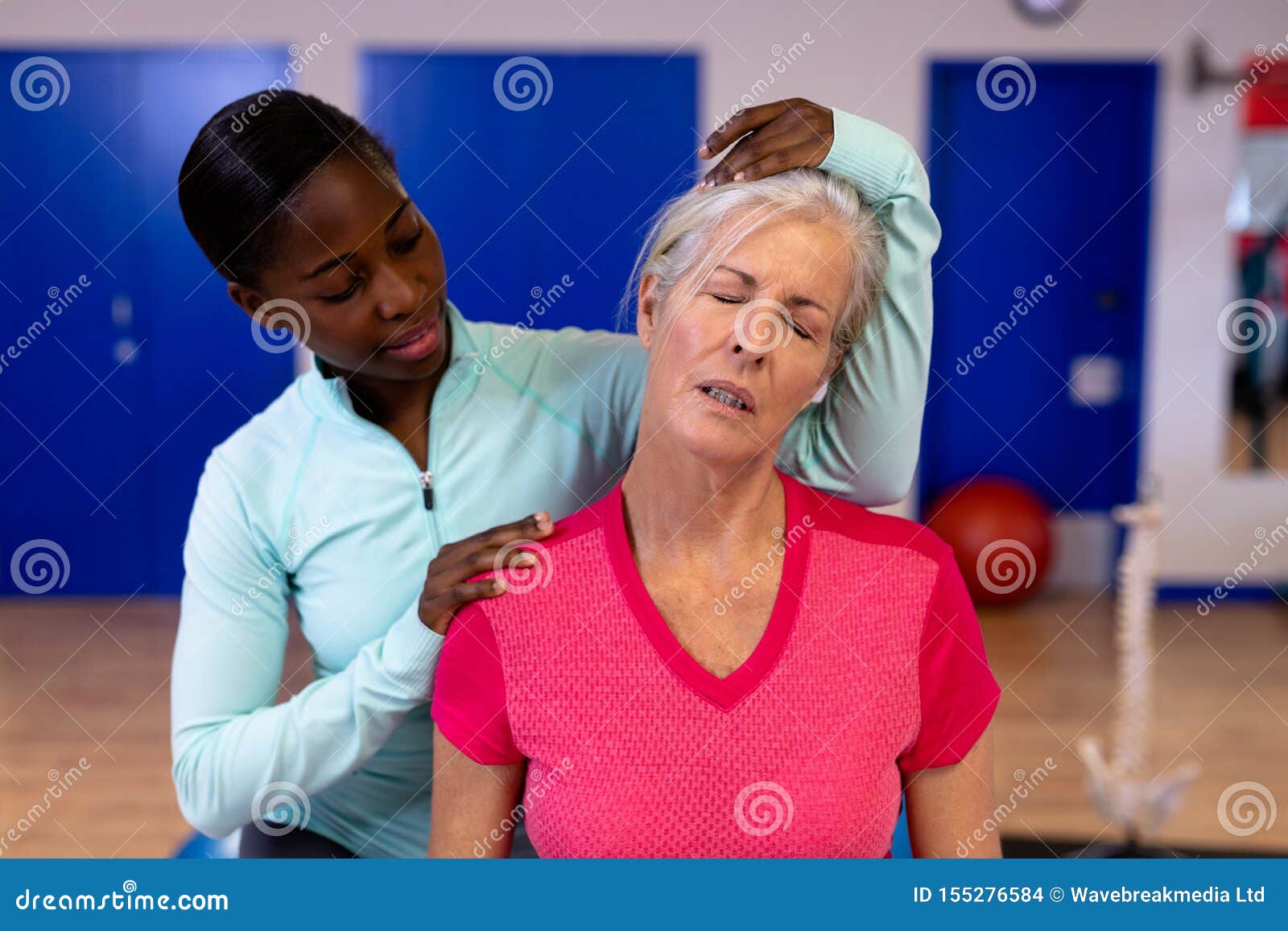 Female Physiotherapist Giving Neck Massage To Active Senior Woman In