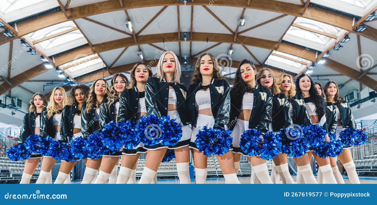 Three Cheerleaders In Blue And White Uniform And Pompoms Stock