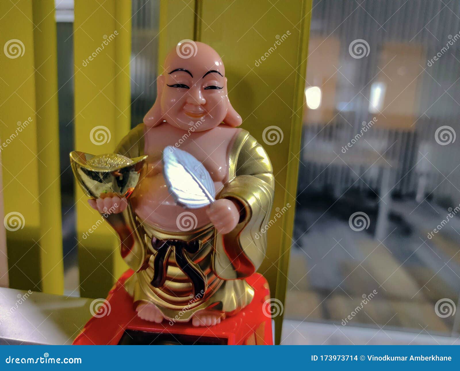 Picture of Front View of a Laughing Buddha Kept on Table in Office
