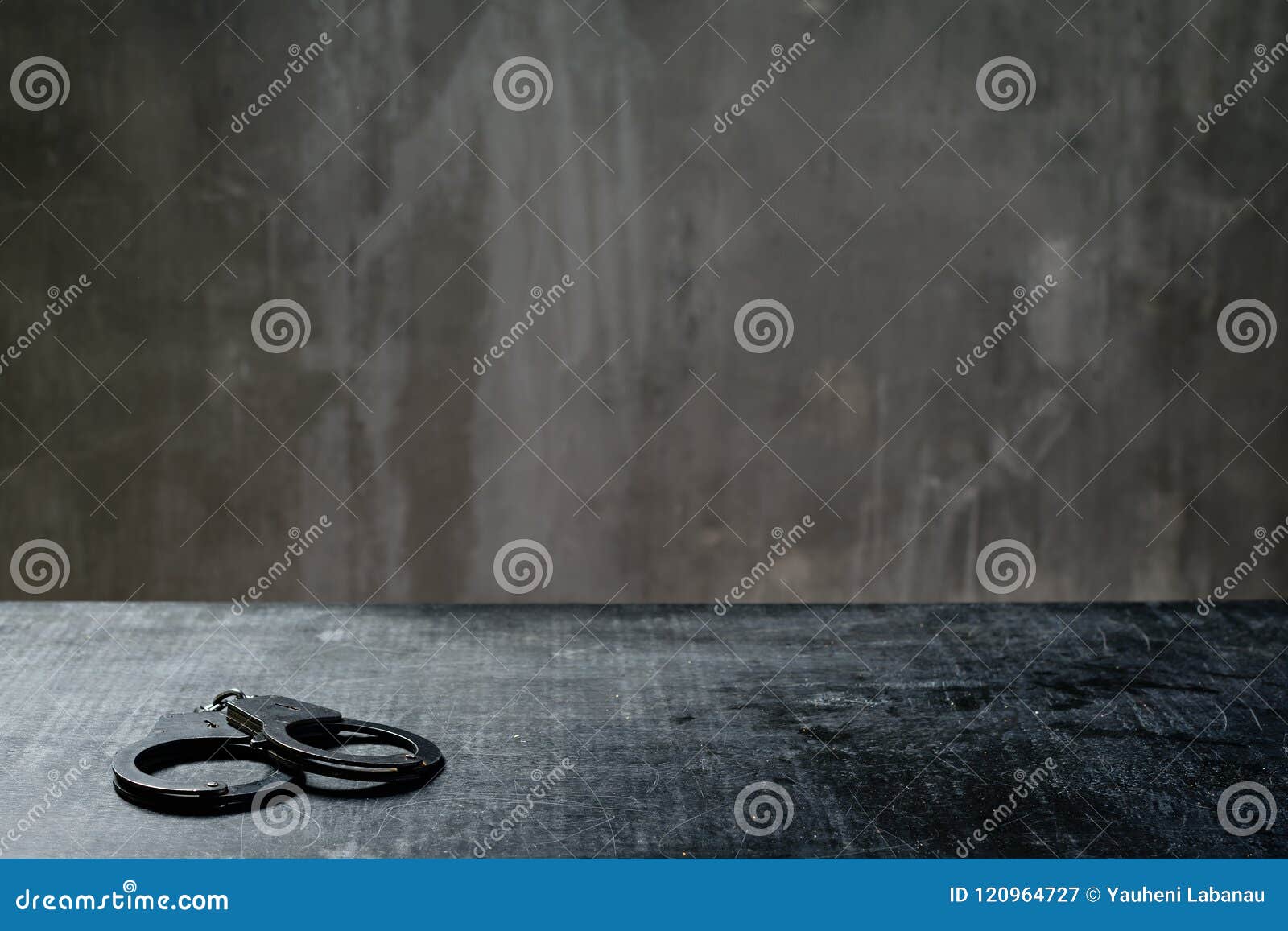 front view of metal handcuffs on table in interrogation room