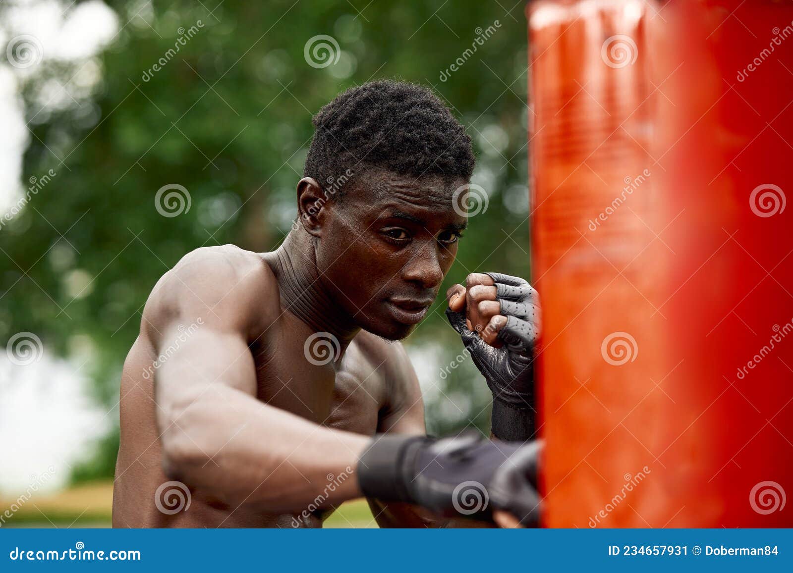 Front View of Muscular Black Boxer Punching Towards Camera with a Deep ...