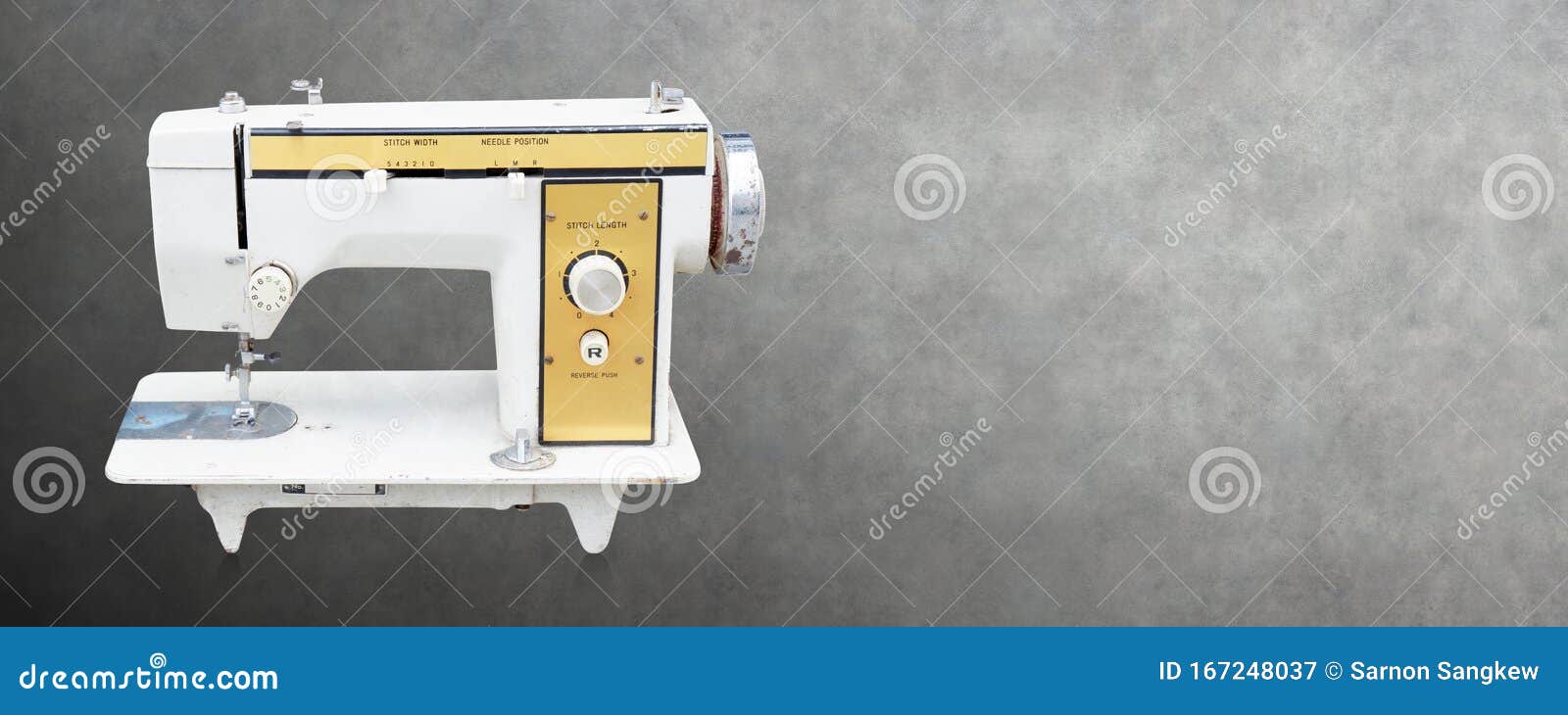 Front View Old White and Yellow Sewing Machine on Cement Background