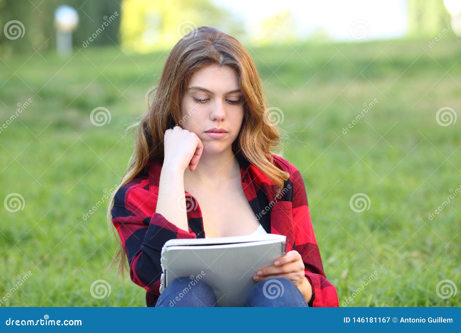 student studying memorizing notes on the grass