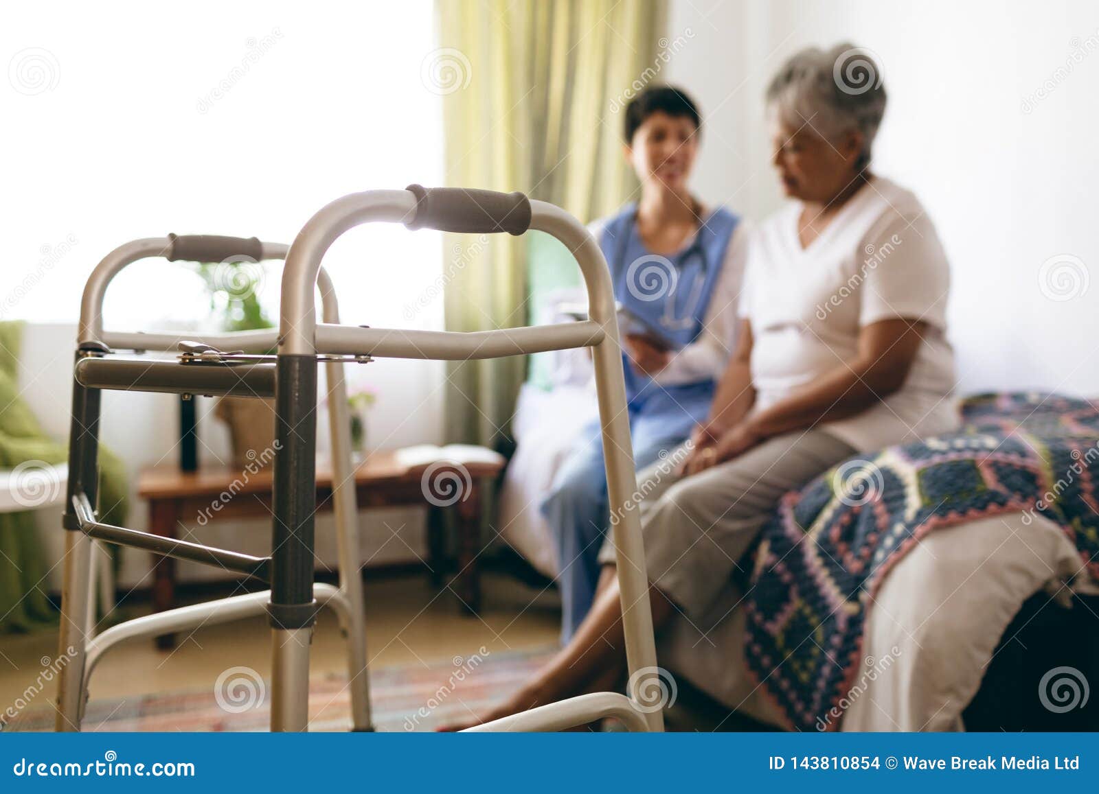 female doctor interacting with senior female patient at retirement home