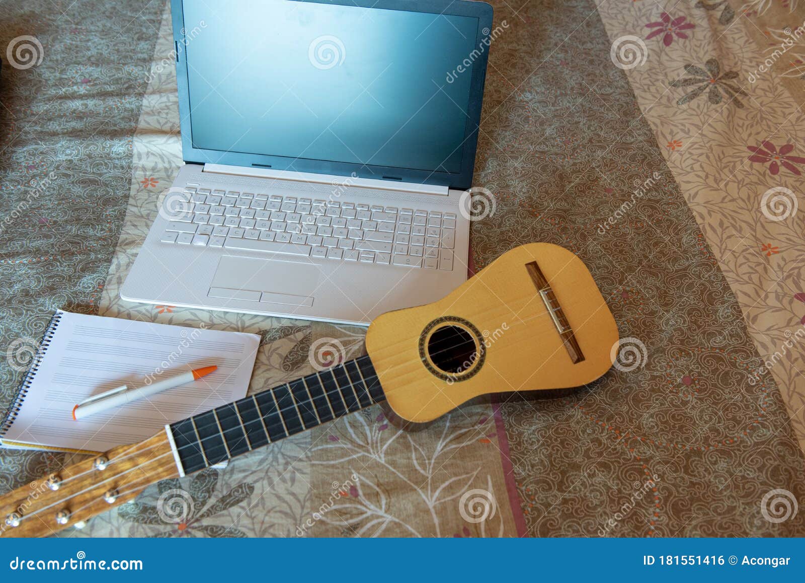 front view workspace with laptop, notebook and timple on bed. free space for your text