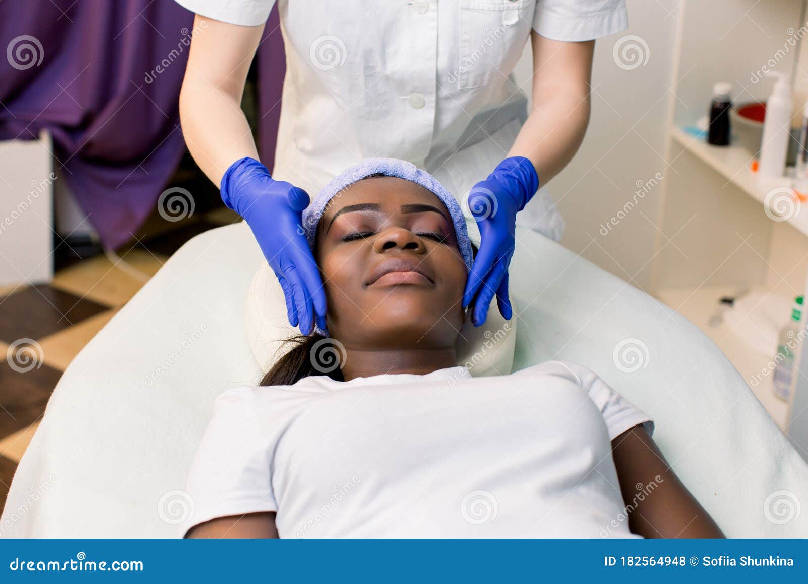 Front View Of Young African Woman Relaxing On Massage Bed Getting