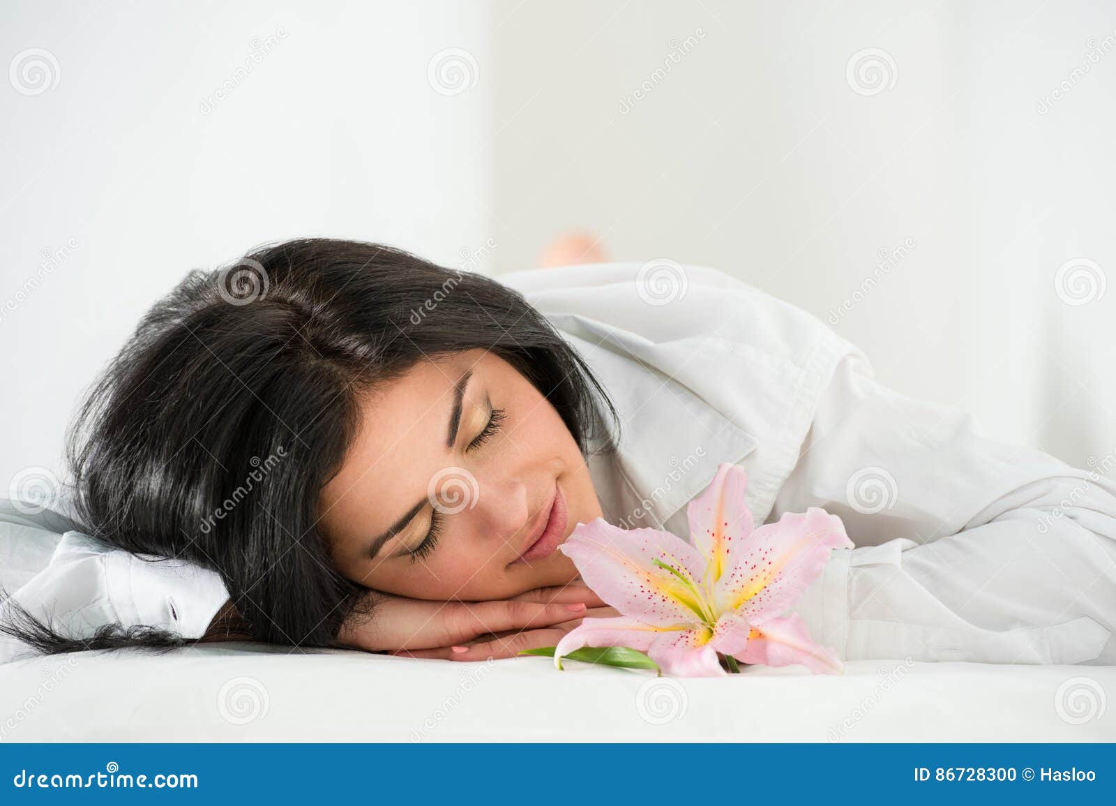 Front View of Young Woman Sleeping on Massage Table in Spa Stock Photo