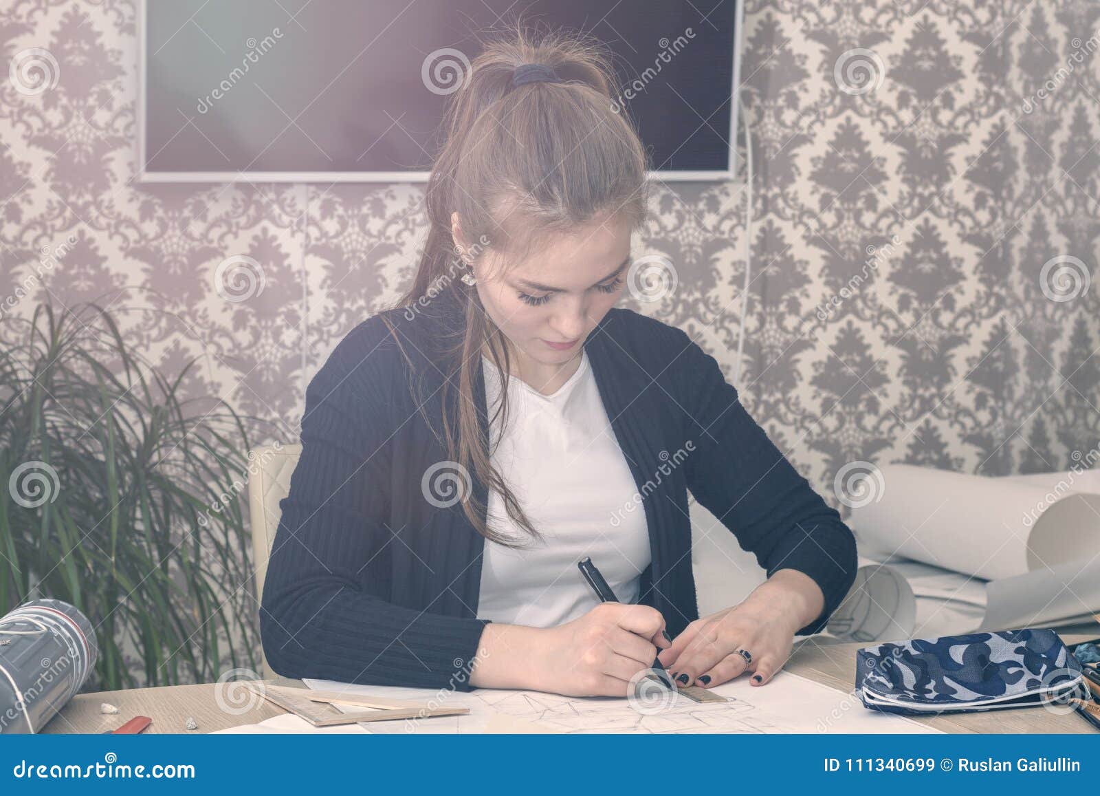Frontal Portrait Of A Young Female Student Is Engaged At The Table
