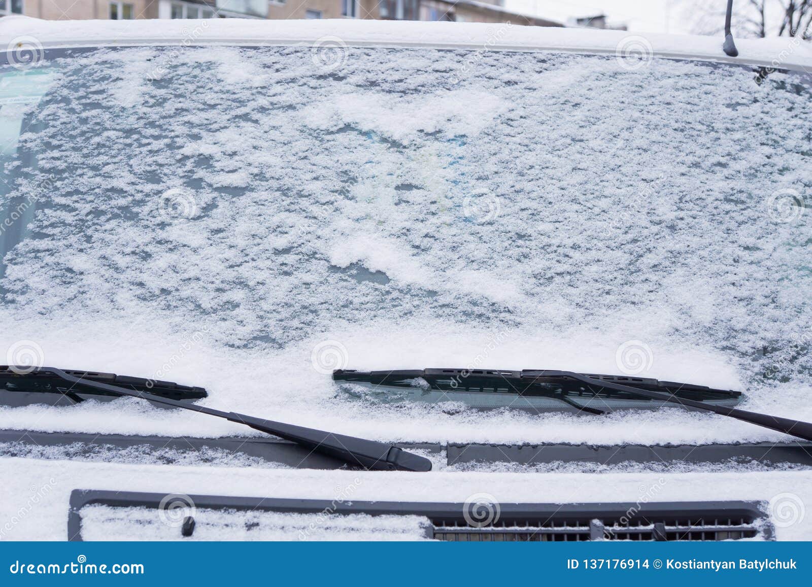 Frozen Car Windshield Covered with Ice and Snow on a Winter Day. Close