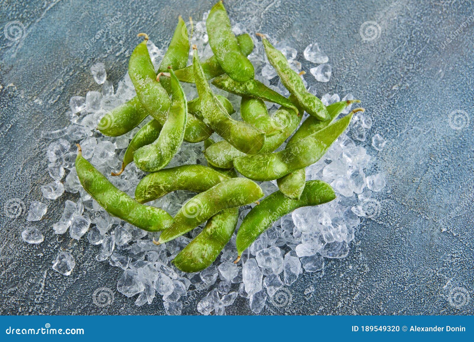 Frozen Edamame or Soybeans in the Mix with Crushed Ice on a Blue