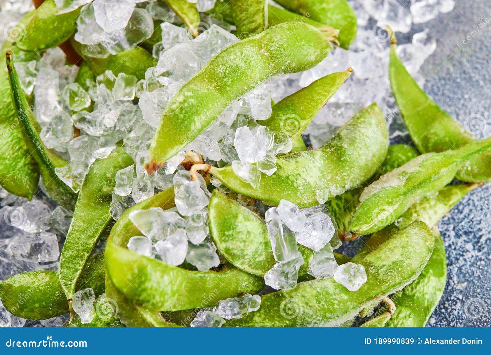 Frozen Edamame or Soybeans in the Mix with Crushed Ice on a Blue