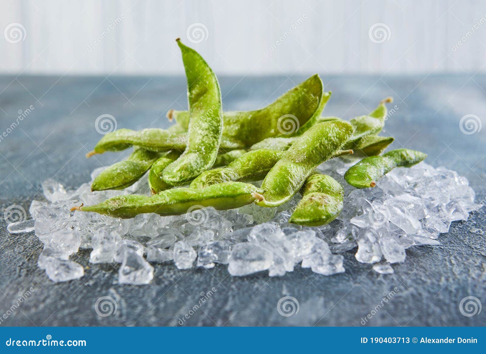 Frozen Edamame or Soybeans in the Mix with Crushed Ice on a Blue