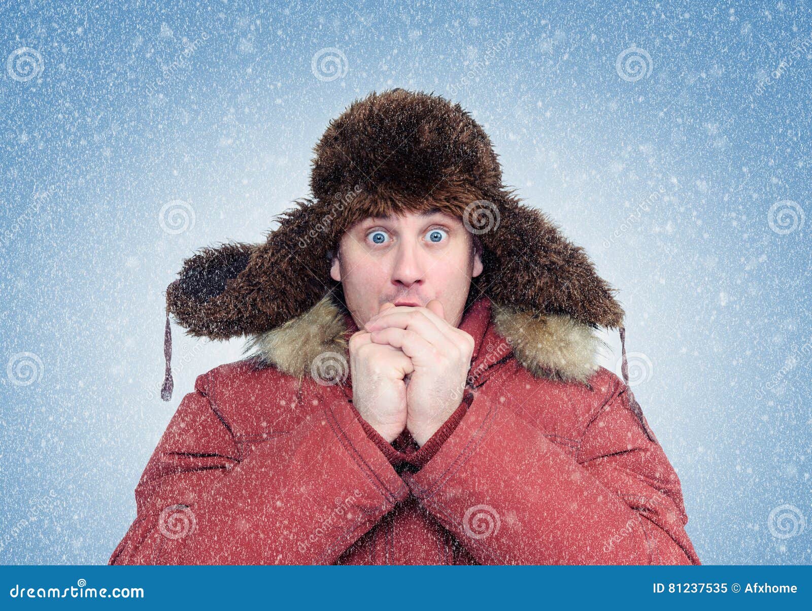 frozen man in winter clothes warming hands, cold, snow, blizzard