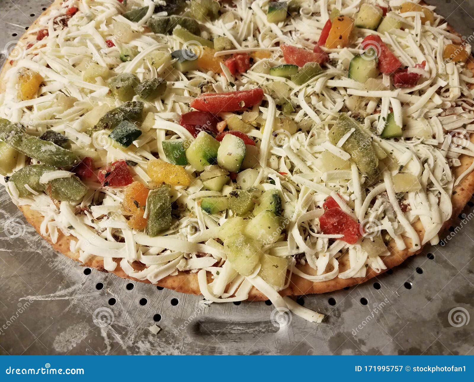 Frozen Vegetable Pizza with Cheese on Metal Baking Tray Stock Image