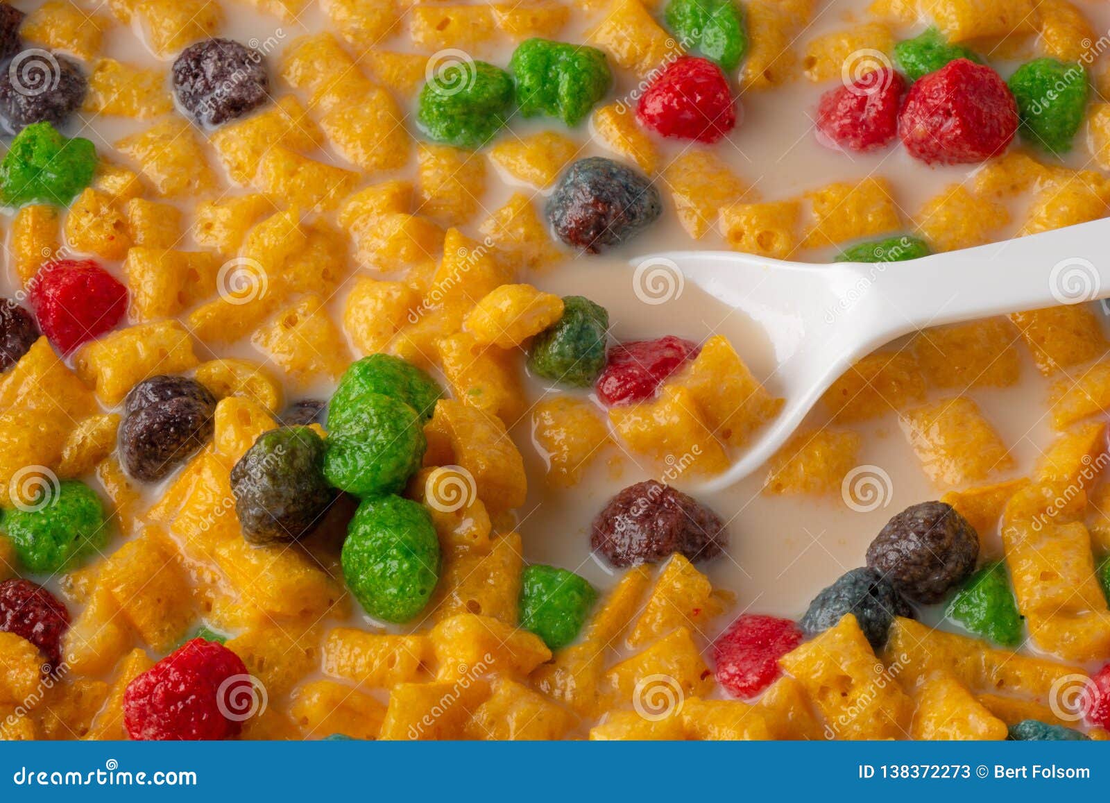 Fruit Flavored Breakfast Cereal with Milk and a White Spoon Stock Image