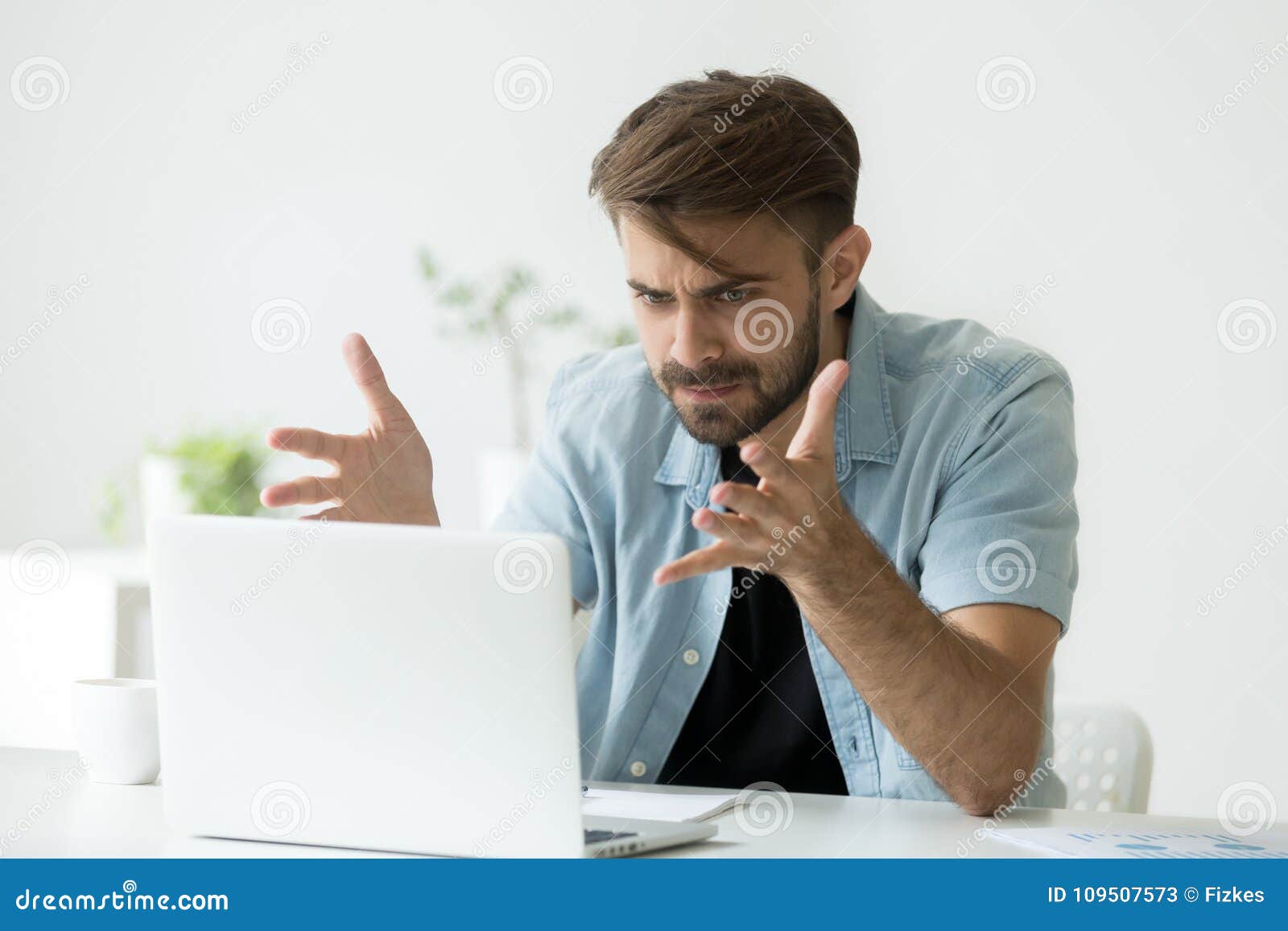 angry man disagree with fake online news looking at laptop