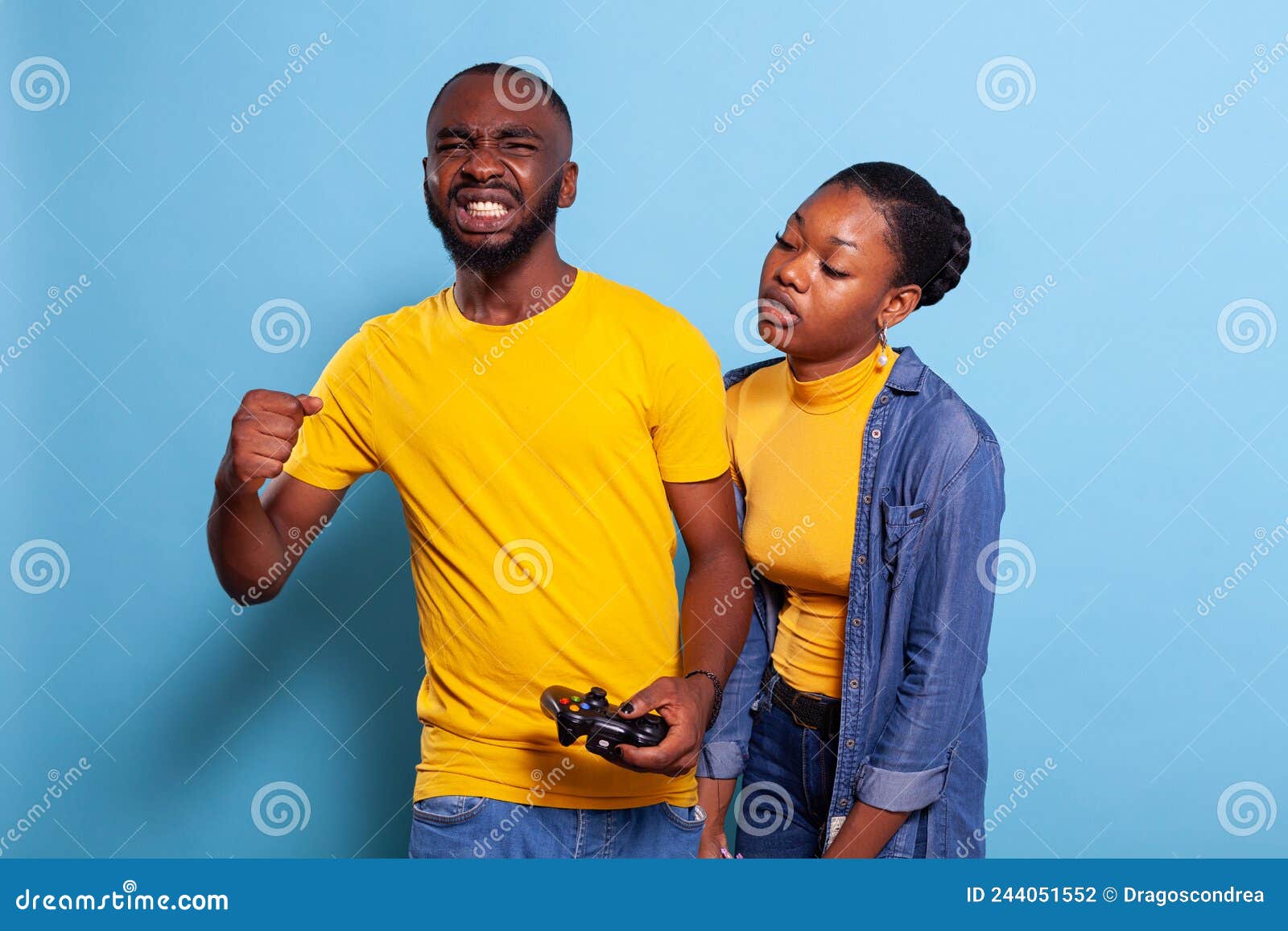 Man beating woman at video games with controller on console over blue  background. Boyfriend celebrating win and girlfriend feeling disappointed  about losing online gameplay in studio Stock Photo - Alamy