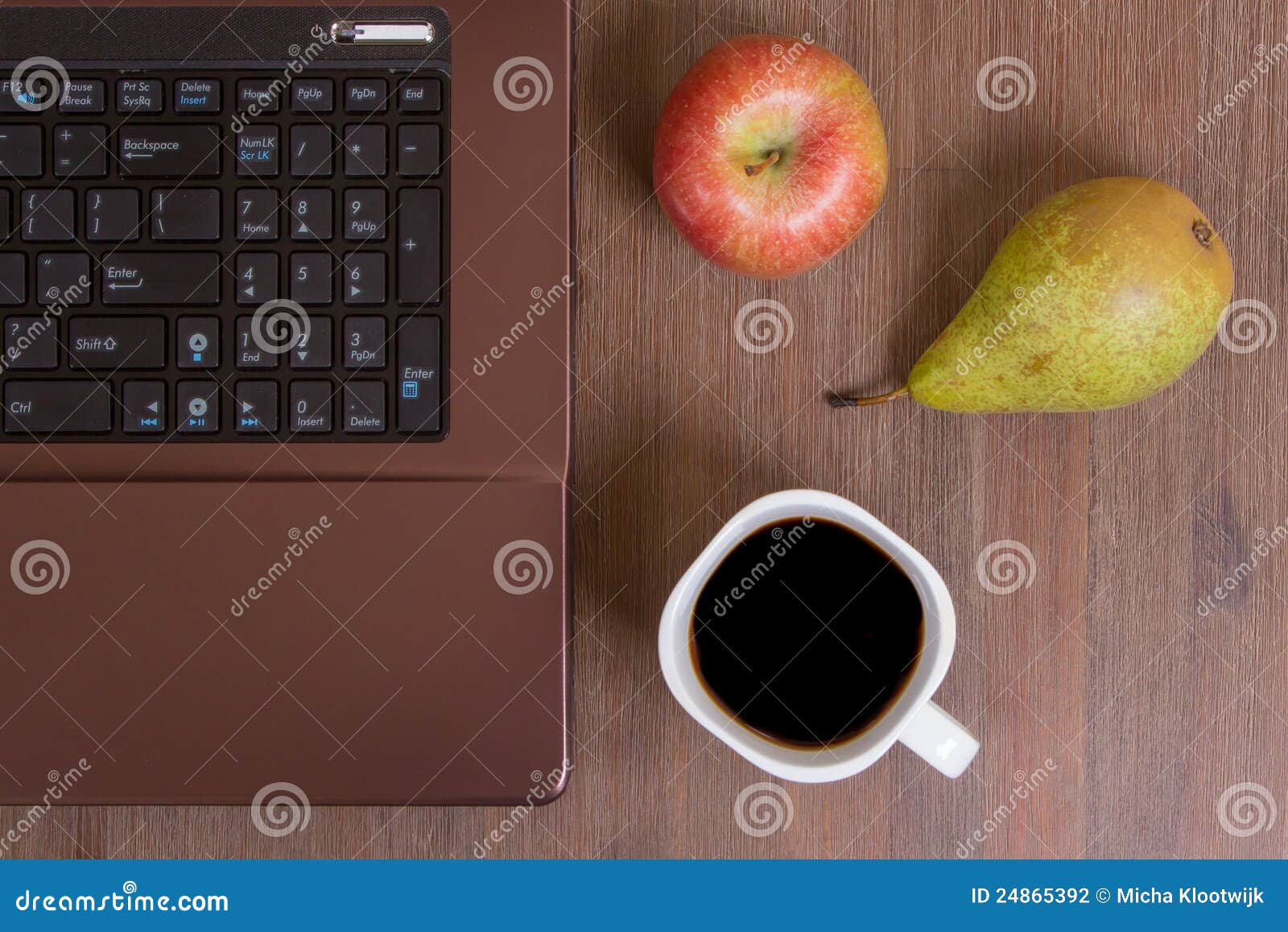 Fruta e café com um portátil em um assoalho de madeira