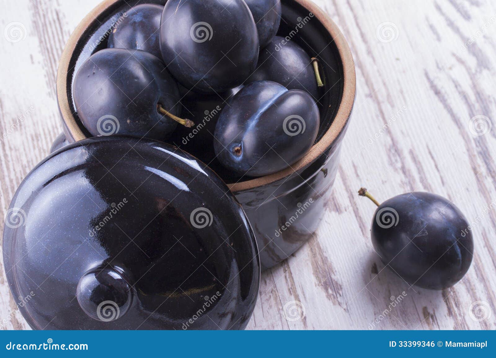 Frutas. Ciérrese encima de la foto de los granos de un café en la taza blanca en un fondo de madera sólido oscuro.