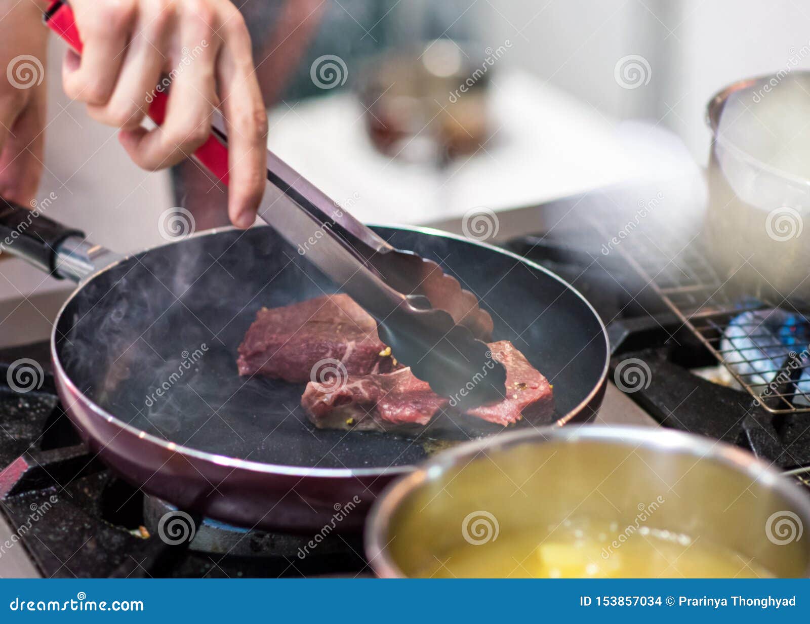 Fry the Meat in a Frying Pan. Chef Preparing and Spicing Meat