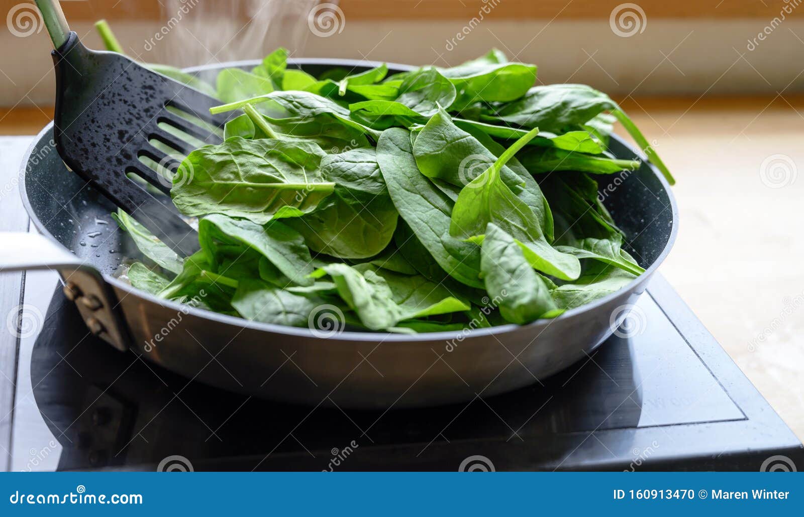 Frying Fresh Spinach In A Pan On The Stove, Healthy Cooking At Home