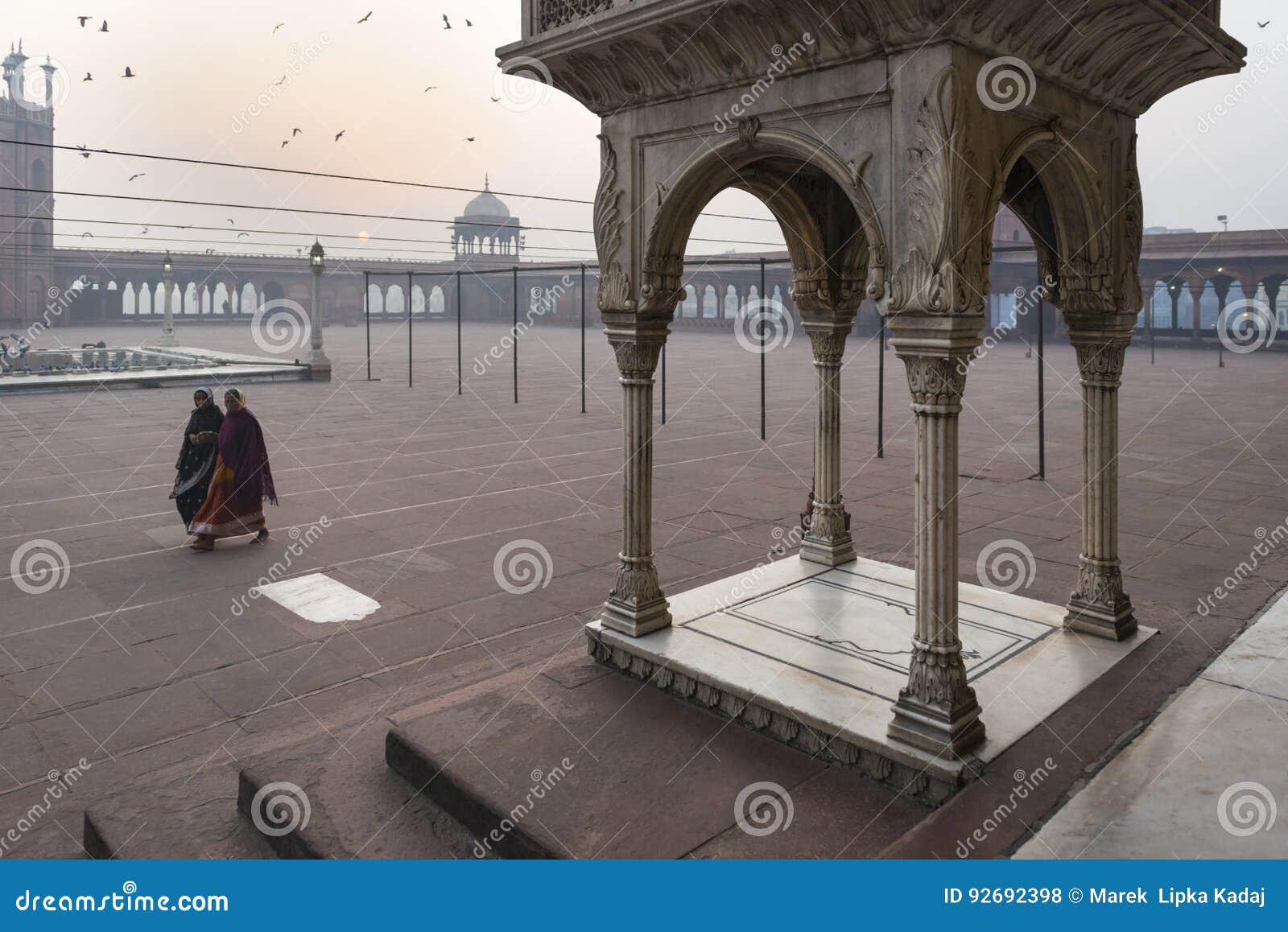 Früher Morgen bei Jama Masjid, Delhi, Indien. Delhi, Indien - 11 Novemver 2012 - die Frauen, die in den Hof bei Jama Masjid Mosque am frühen Morgen gehen, beleuchten in Delhi