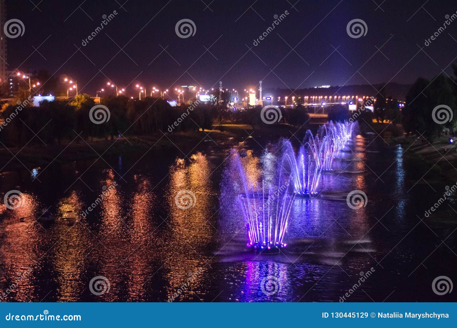 Fuentes luminosas coloreadas en el medio del lago en la noche Kiev, Ucrania