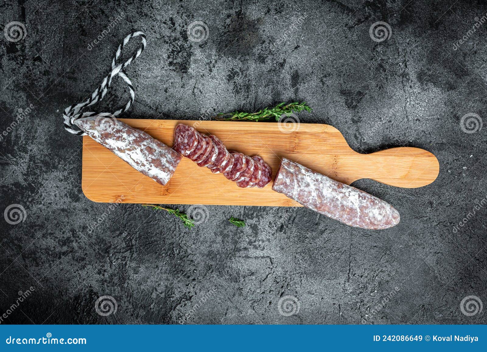fuet salami cut in slices. traditional spanish sausage on wooden board. fuets catalan dry sausages. top view