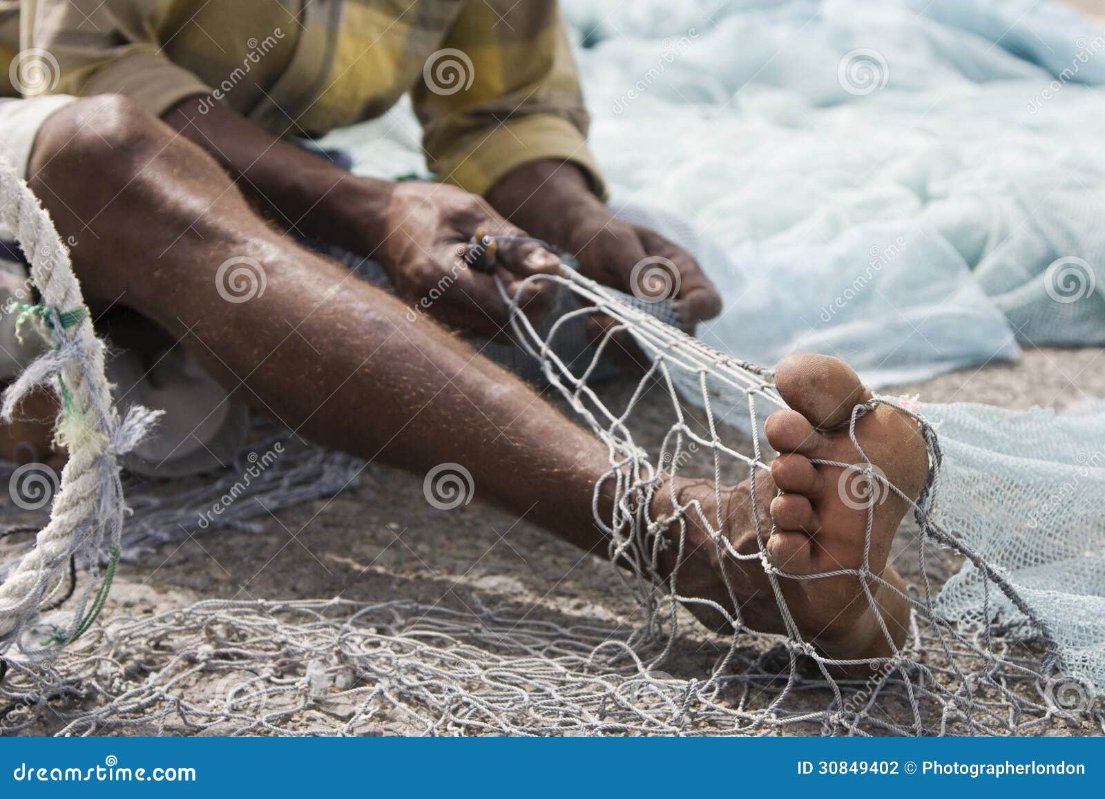 fujairah uae a local fisherman fixes holes and tangles in his net in fujairah.