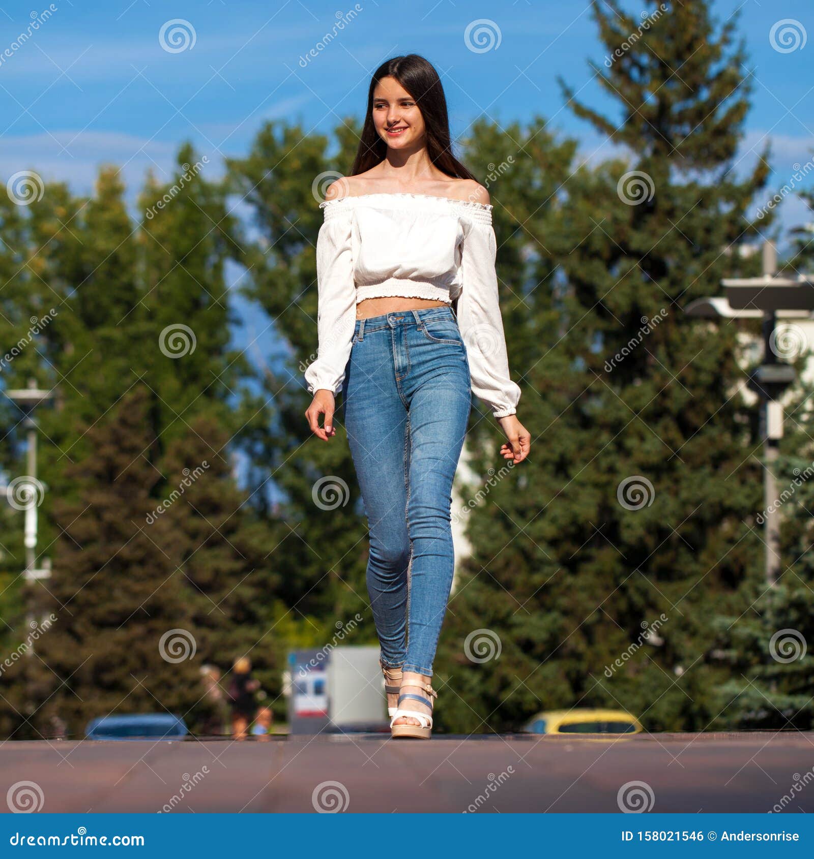 Young Beautiful Brunette Woman in Jeans and White Blouse Walking in ...