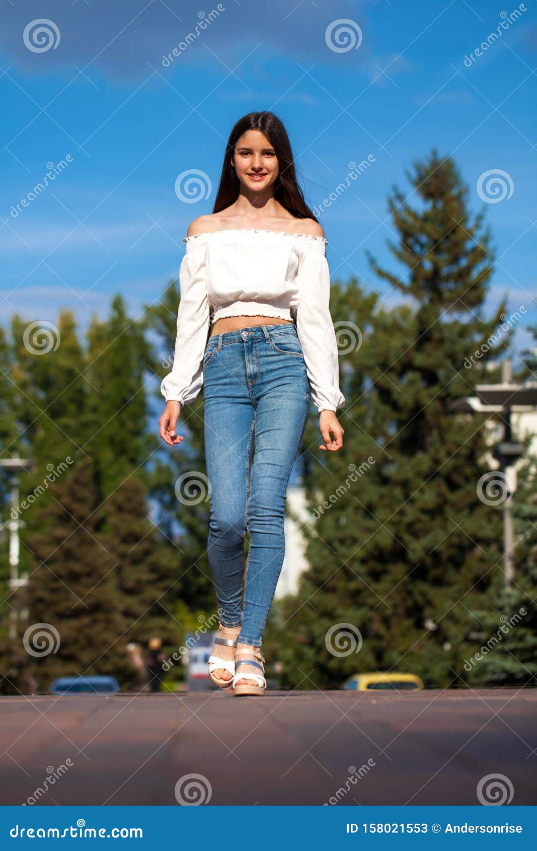 Young Beautiful Brunette Woman in Jeans and White Blouse Walking in ...