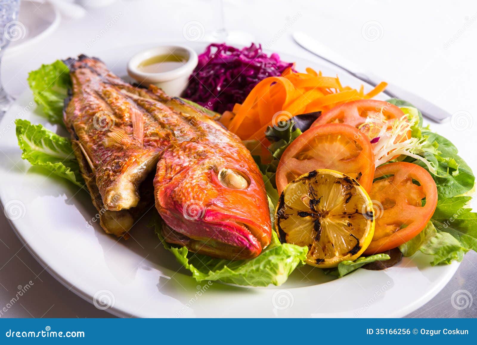 Full Cooked Tilapia Served with Vegetables and Fish Sauce Stock Photo