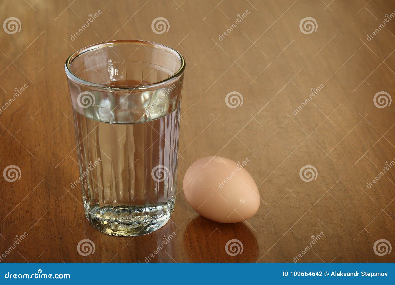A Full Glass Of Water And One Egg On Scratched Brown 