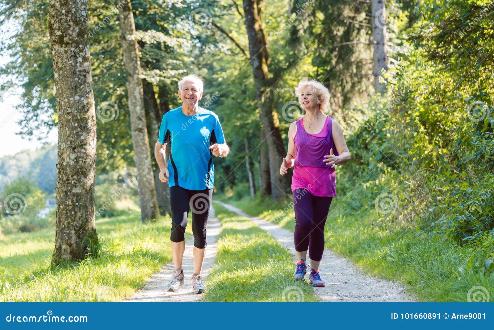 two active seniors with a healthy lifestyle smiling while joggin