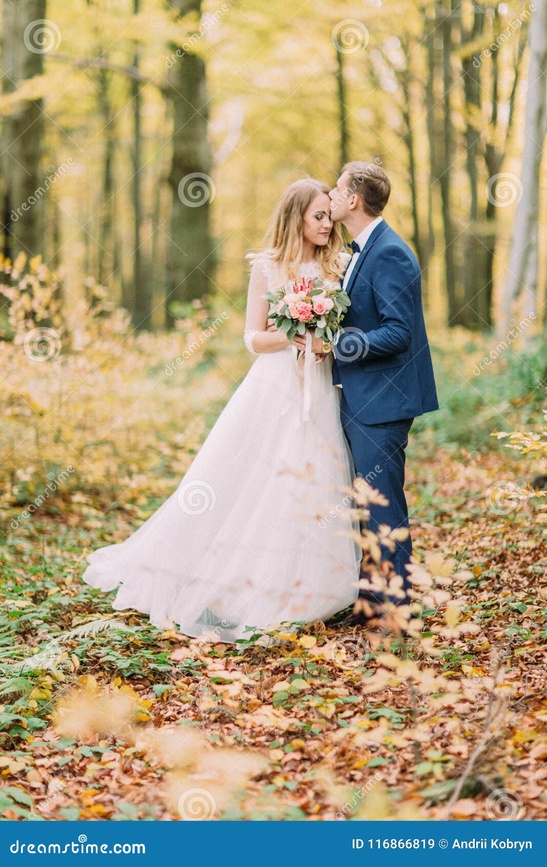 Full Length Photo Of The Groom Kissing The Bride In The