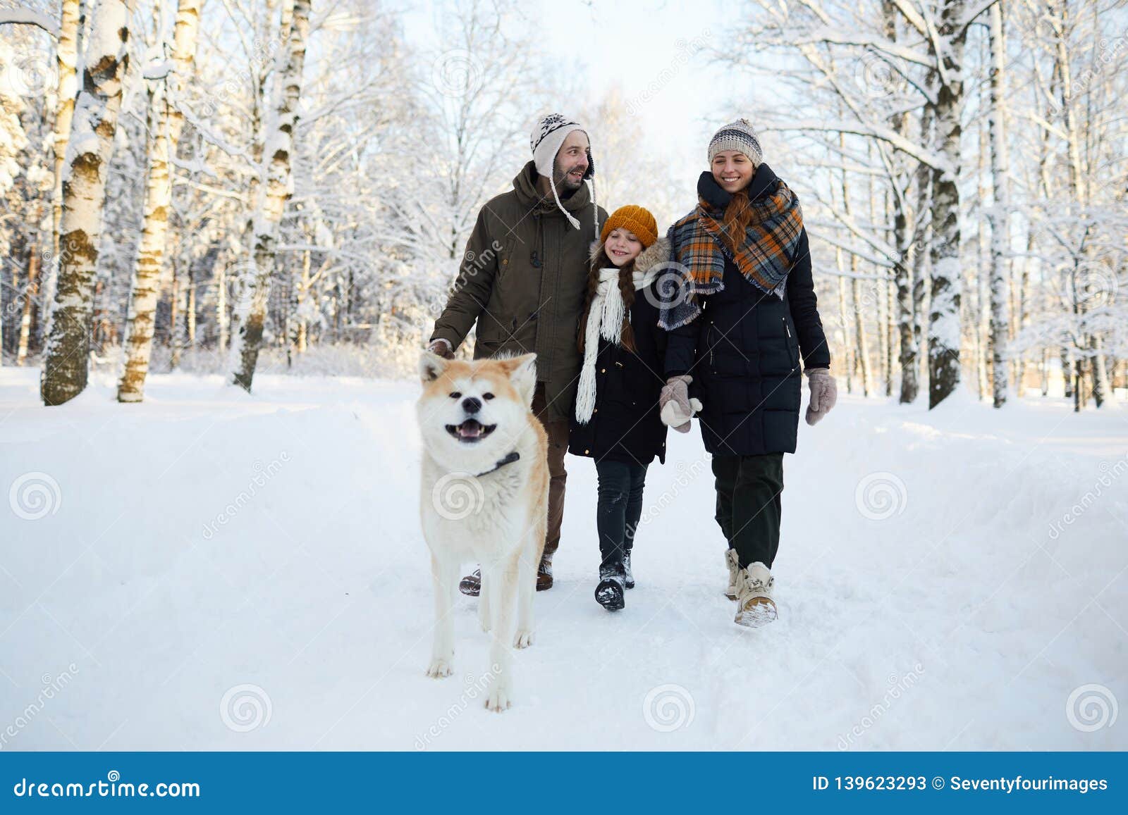 family walking dog in winter