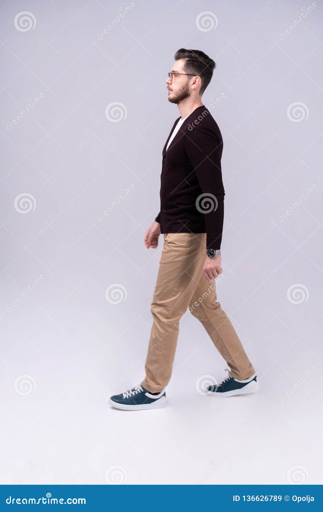 Full Length Portrait of a Smiling Young Man Walking Isolated Over Gray ...