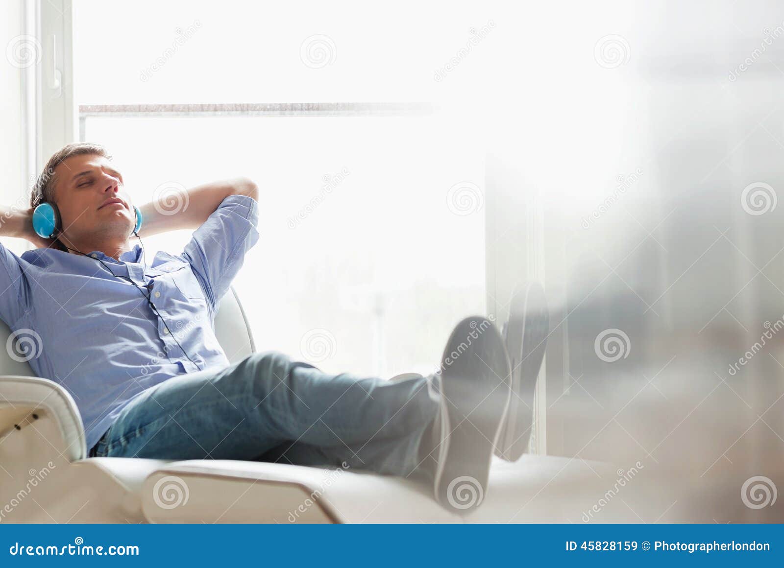 full-length of relaxed middle-aged man listening to music at home