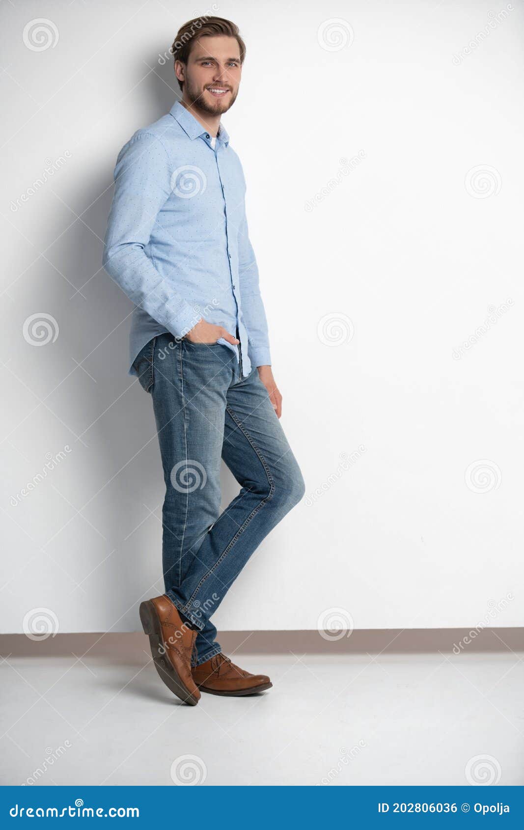 full length studio portrait of casual young man in jeans and shirt.  on white background.