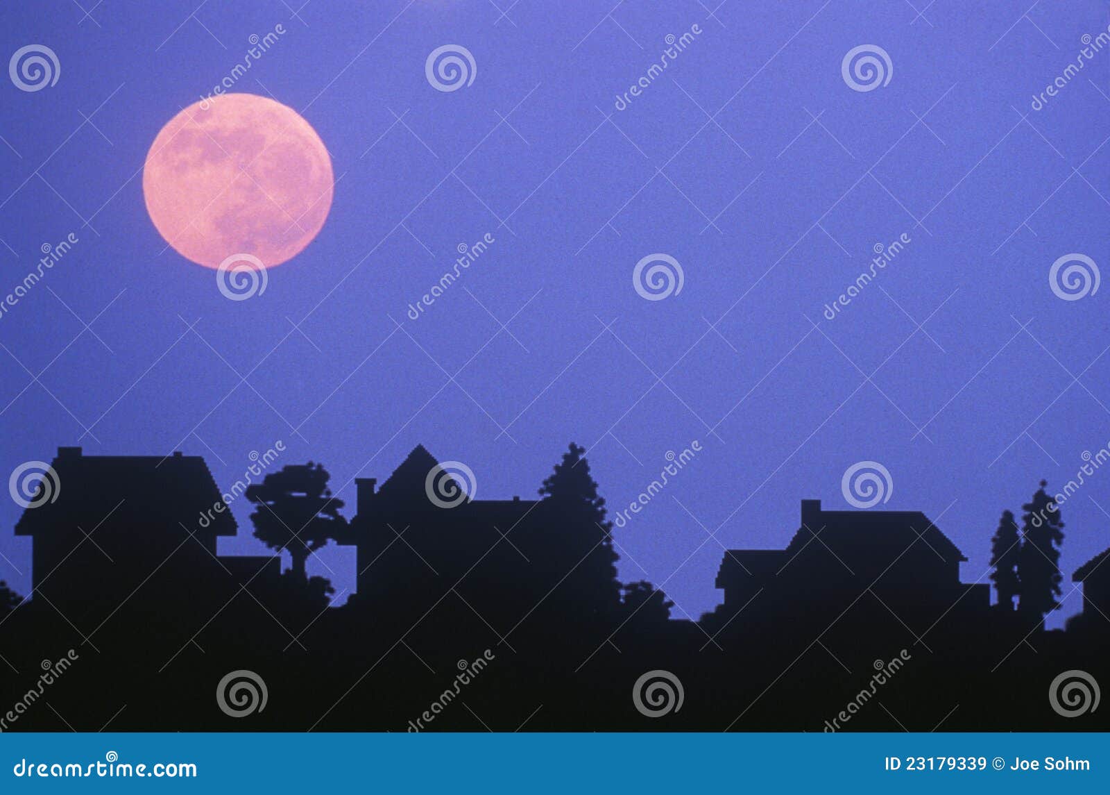 Silhouette of full moon over family homes in typical neighborhood