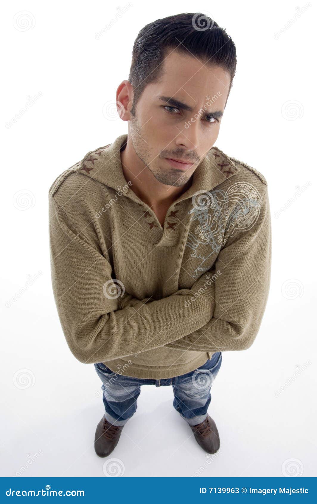 Portrait Of Fashionable Boy Wearing Denim Posing In Dark Studio Background  With Hand In Pocket While Fixing His Shirt And Looking Away From The Camera  Stock Photo, Picture and Royalty Free Image.