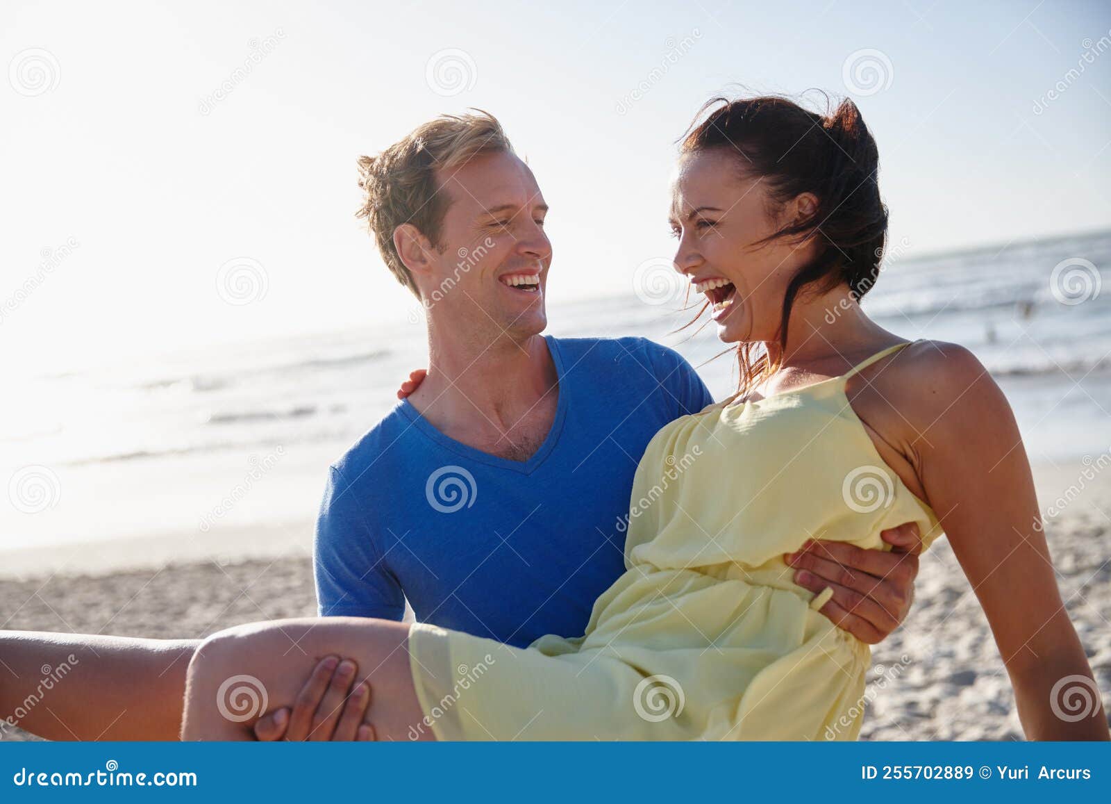 Fun On The Beach A Handsome Man Carrying His Wife On The Beach Stock 