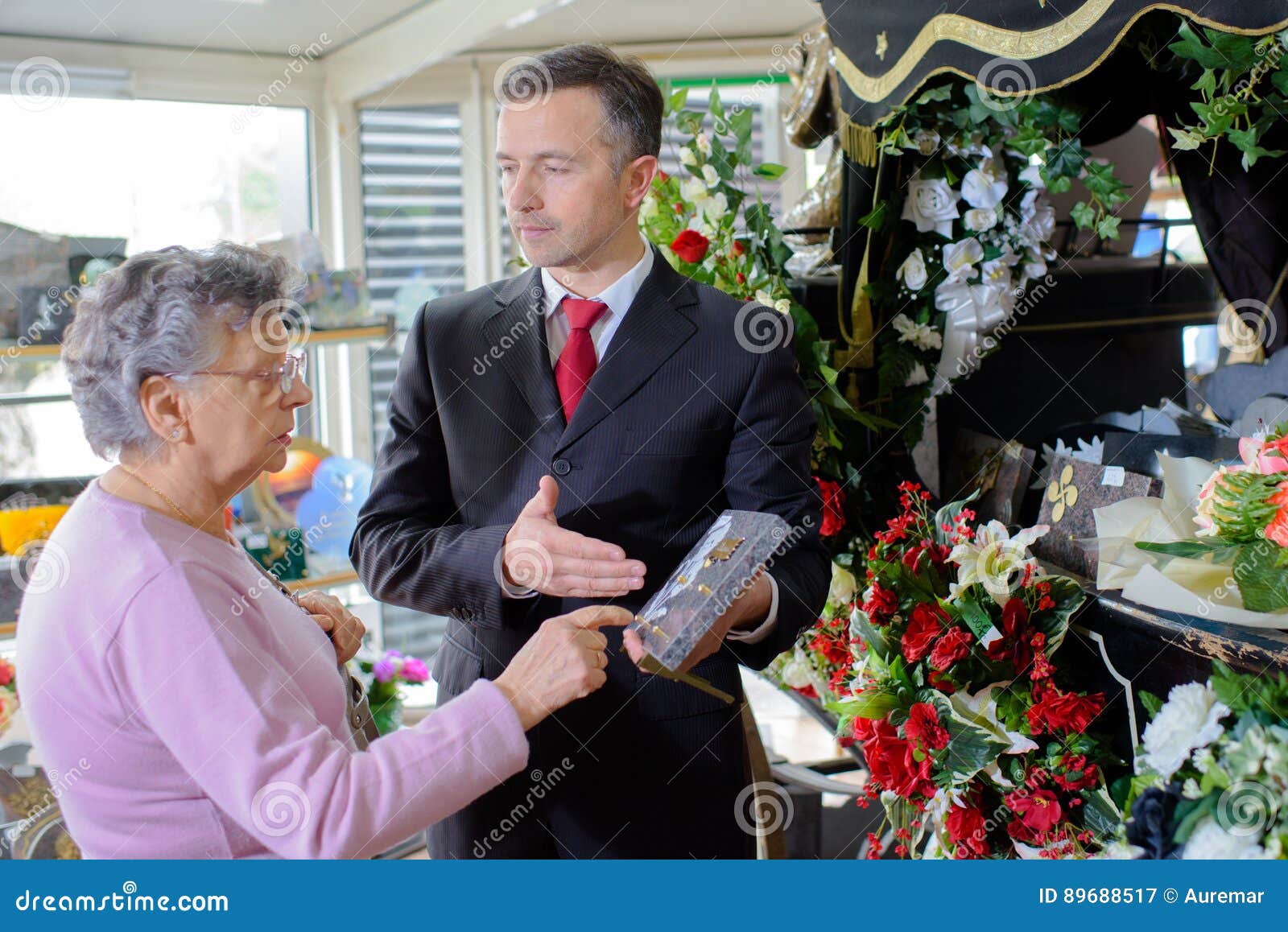 funeral director showing woman memorial plaque