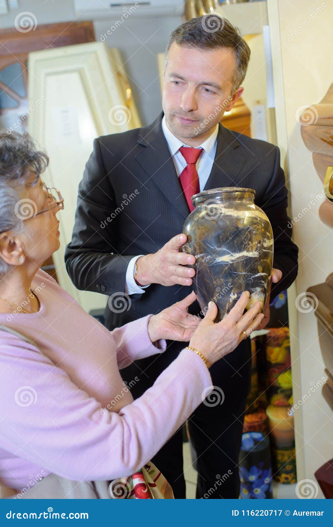 funeral director with widow choosing urn