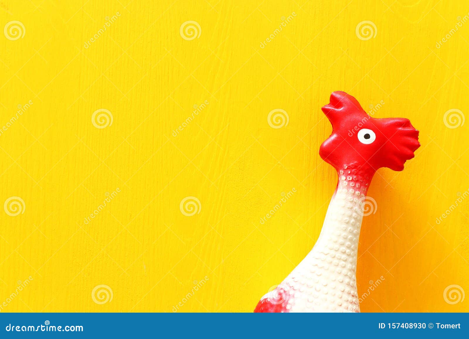 Funny Background of Rubber Chicken Toy on Yellow Table Stock Photo