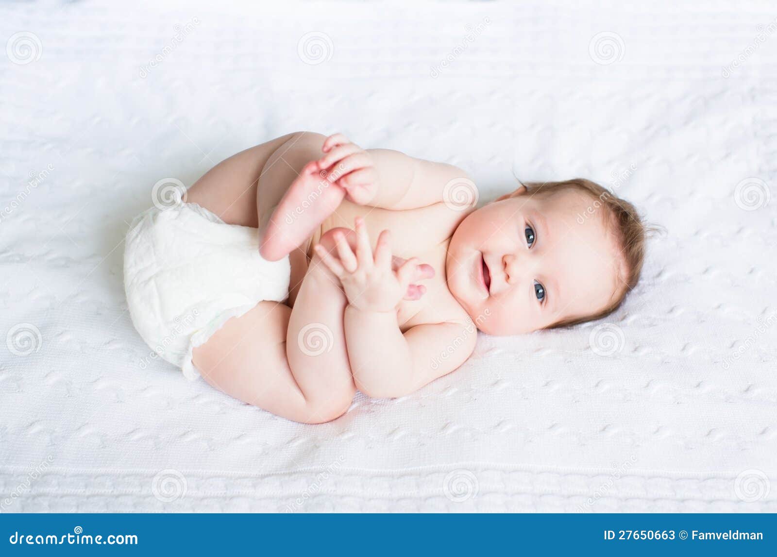 funny chubby baby playing with its feet